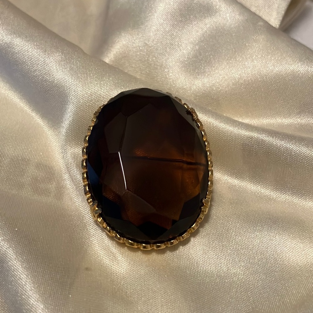 Vintage Brown Stone Gold Toned casing Broach. Large Stone is clear. No scratches